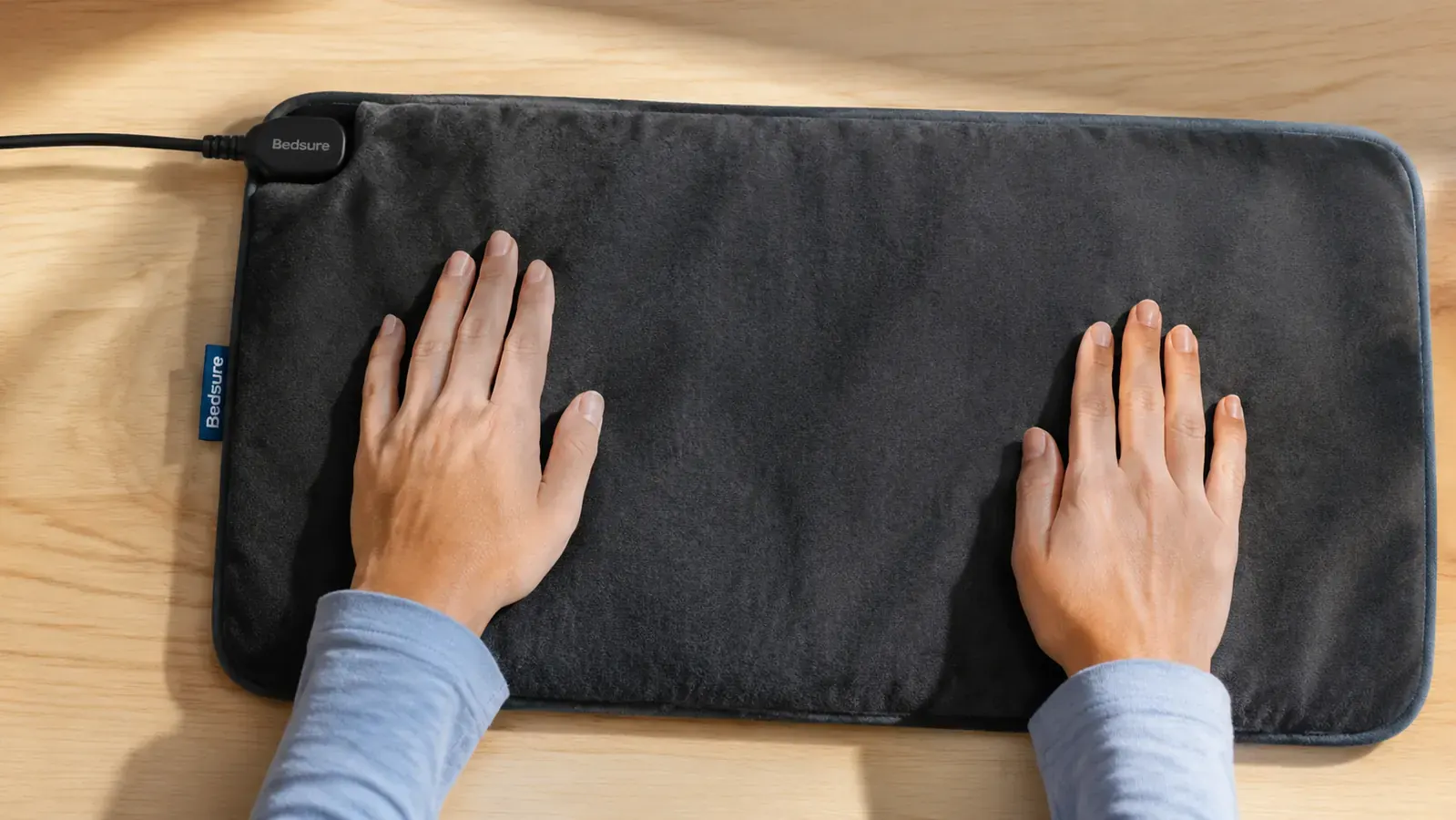 The Bedsure heating pad laid flat on a surface showing the cord outlet position and the fabric texture up close