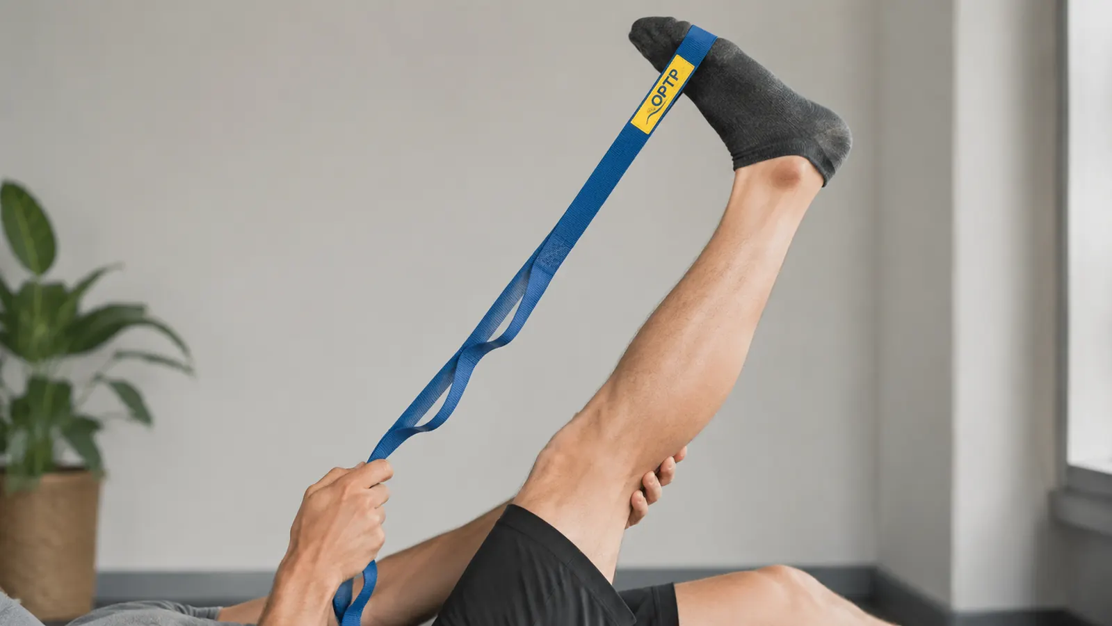 Close-up of the OPTP Stretch Out Strap loops with a hand gripping at different loop positions to adjust stretch intensity