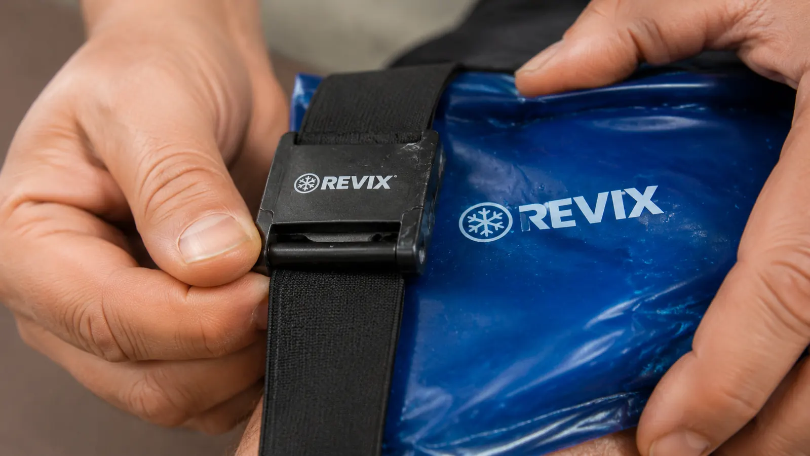 Close-up of the REVIX ice pack strap clip after extended use, showing wear marks on the plastic